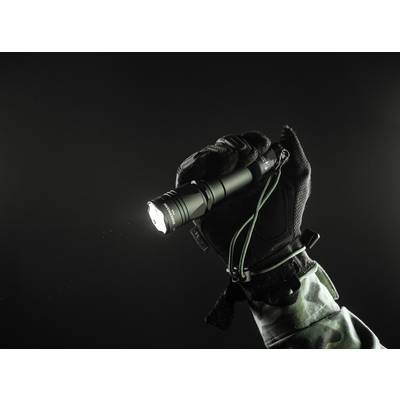 A gloved hand holds a switched-on torch against a dark background, emphasised by a military sleeve.