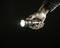 A hand holds a switched-on torch, illuminating a dark room.