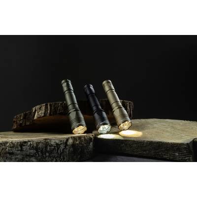 Three torches in different colours stand on wooden blocks and shine softly against a dark background.