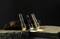 Three torches in different colours stand on wooden blocks and shine softly against a dark background.