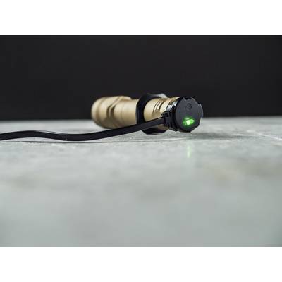 A torch is being charged via a cable. A green LED lights up on the charging port, indicating the charging process.