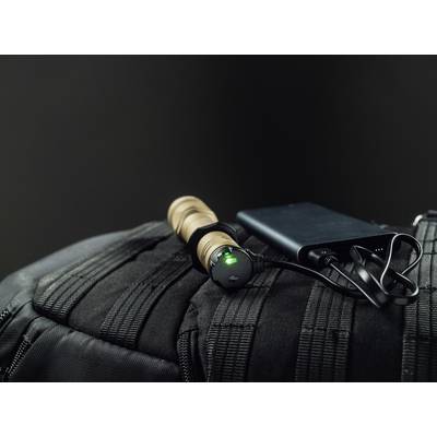 Torch with green light on a black rucksack, connected to a portable charger, against a dark background.
