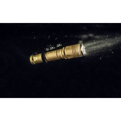 A golden waterproof torch illuminates underwater and creates small bubbles. It is angled upwards to the right.