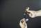 Two hands are holding a torch and a removed, marked battery that is being inserted or removed.