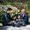 'Optimised Performance. Developed for High-Consumption Devices.' Two people are testing a remote-controlled car outdoors.