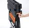 A person is folding up a black collapsible workbench with orange details.