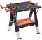 'Folding workbench with a black frame and orange accents, fitted with adjustable brackets, perfect for workshop tasks.'