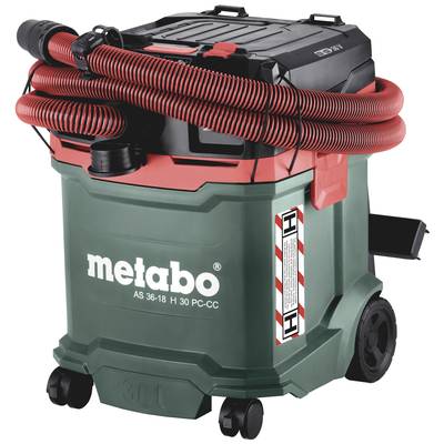 A green industrial vacuum cleaner by Metabo with a red and black hose, mounted on wheels, designed for cleaning construction sites and workshops.