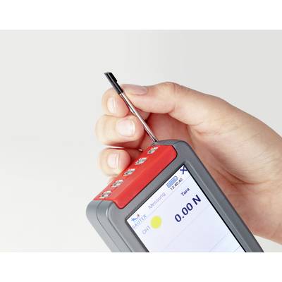 A hand is holding a digital force measuring device with a display showing '0.00 N'. A pen is inserted which serves for measurement.