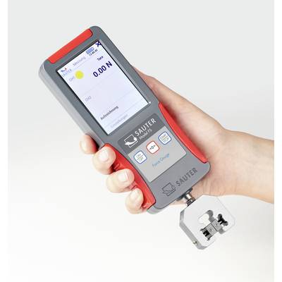 A hand holds a digital force measuring device by Sauter. The display shows a measurement value of 0.00 N.