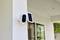 Security camera with solar panel installed on the wall of a modern house.