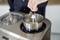 A person lifts the paddle out of an ice cream maker to remove the finished ice cream.