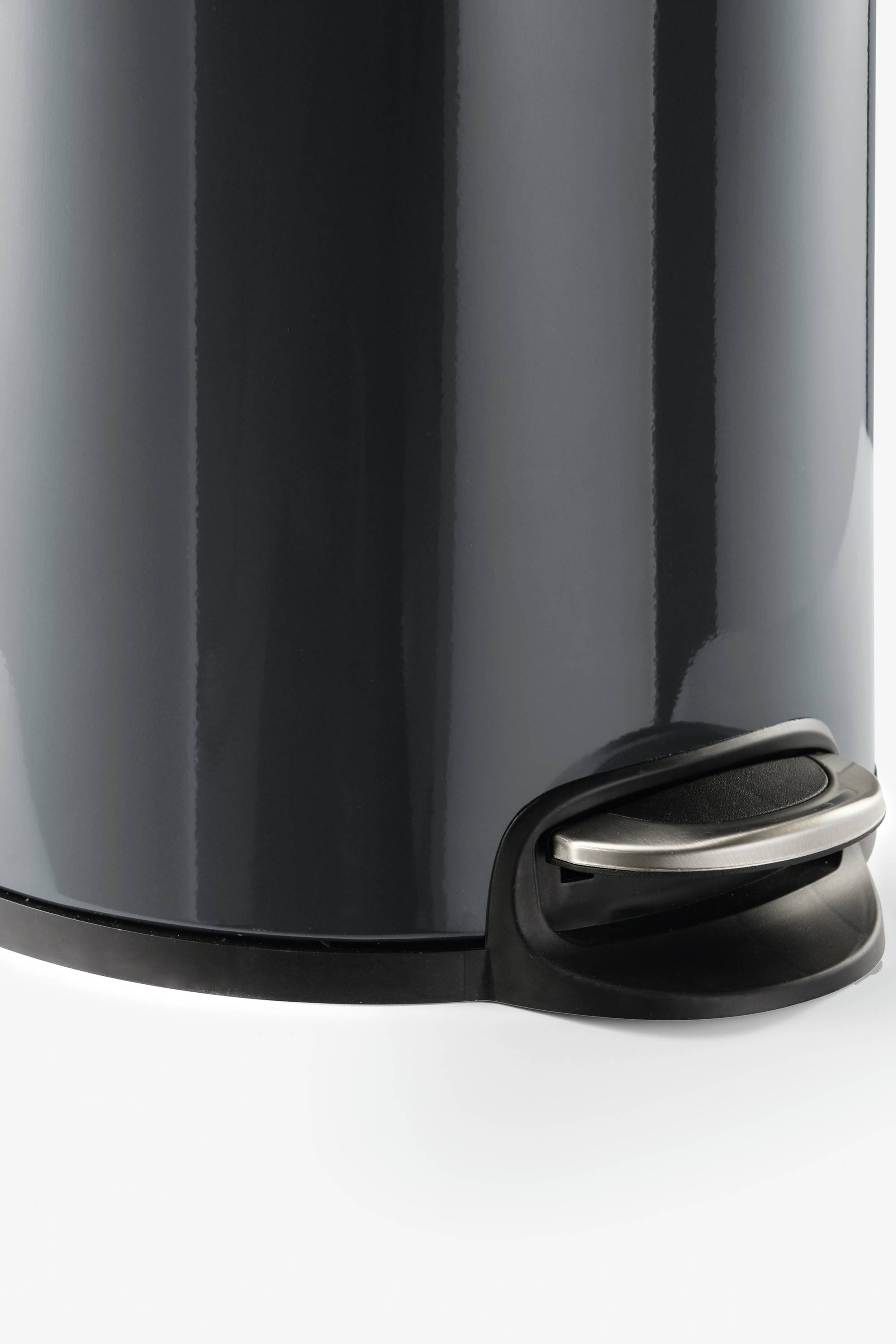 A black pedal bin with a silver pedal at the bottom is positioned against a white background.