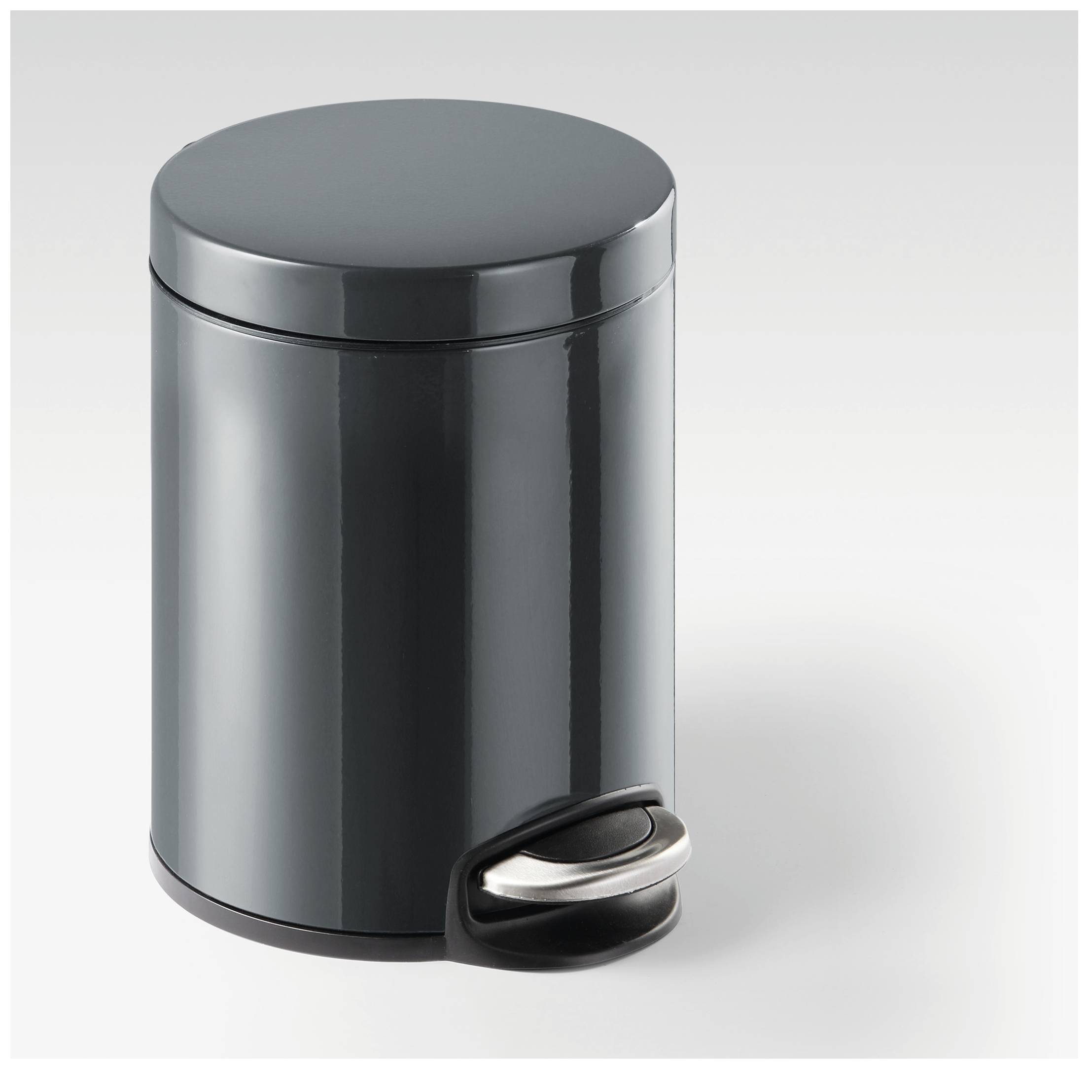 A small, round, grey bin with a pedal at the bottom, standing on a white surface.