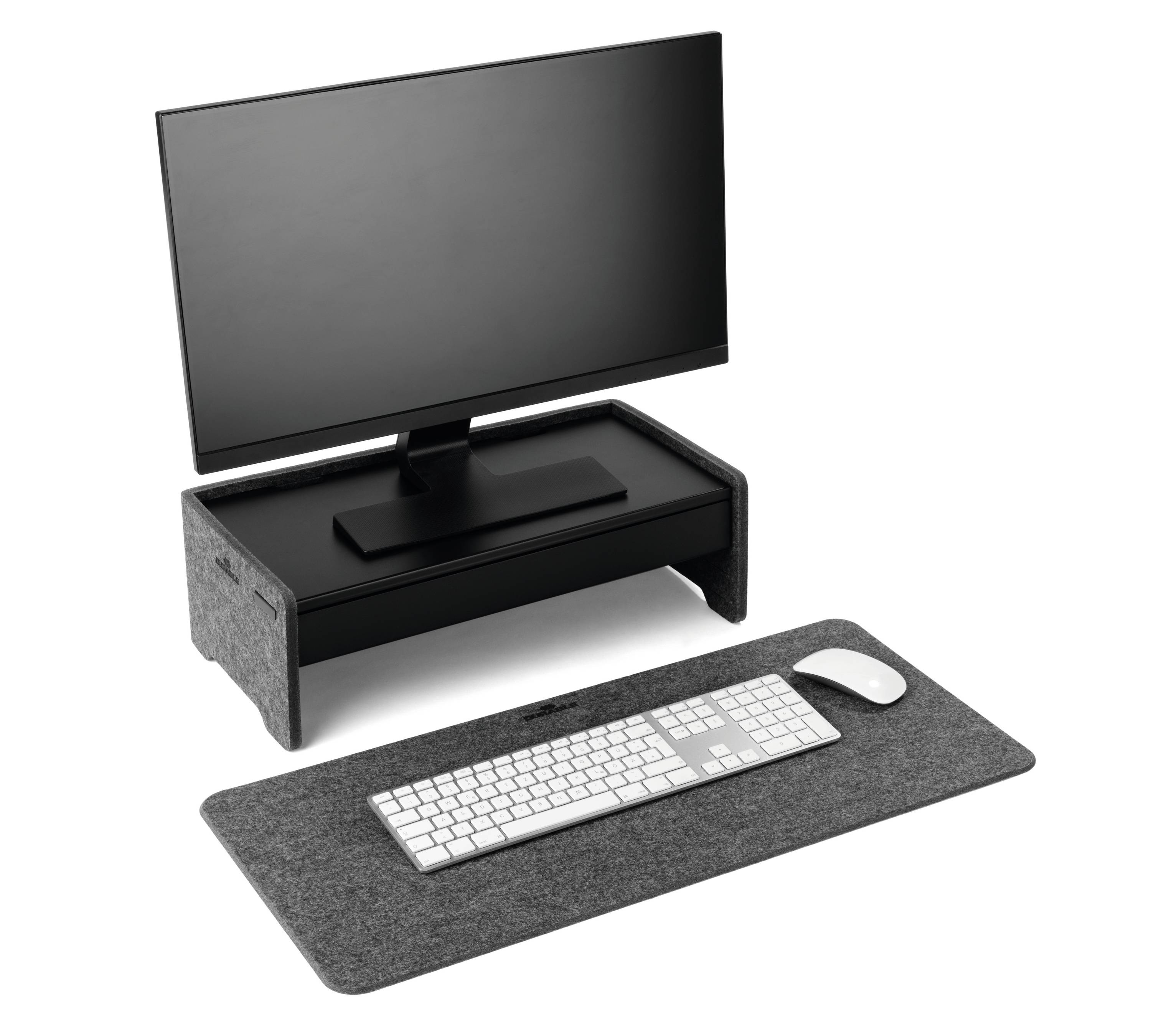 Monitor on a grey elevation, with a keyboard and mouse placed on a grey felt mat in front of it. A tidy office setup.