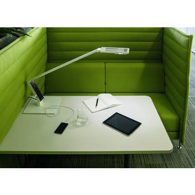 Round table with a tablet, a notebook and a mobile phone. A green upholstered seating area surrounds the table on three sides.