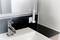 A bathroom with a white washbasin and tap, next to an electric toothbrush in a wall-mounted holder.