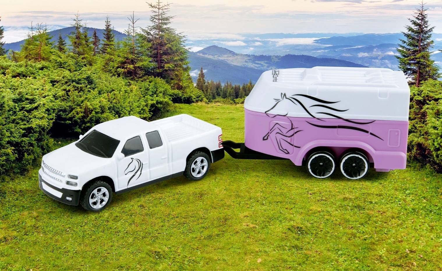 A white pickup truck is pulling a pink horse trailer across a meadow, surrounded by trees and hills in the background.
