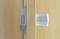 Wooden door gap with a silver door handle and door lock visible. The handle is smooth and cylindrical, the lock is rectangular.