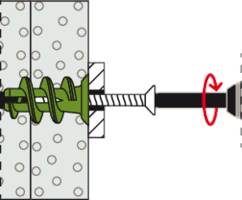 A green wall plug is twisted into a perforated wall. A screw is then screwed through the plug to secure it.
