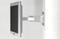 Image of a monitor mounted on a wall bracket. The bracket is adjustable and made of silver metal.