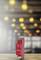 A red smart home device sits in front of a blurred background with yellow light. It displays 'Power' and 'Z-Wave'.