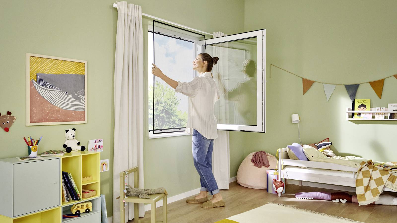 A woman opens a window in a bright children's bedroom with a toy shelf, bed, and colourful wall decorations.