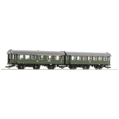 Green railway carriage in model format, photographed from the side, standing on a track. Clearly visible details of windows and wheels.
