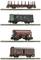 Four model railway goods wagons on tracks: an open timber transporter, a green luggage van, a bulk goods wagon, and an enclosed goods wagon.