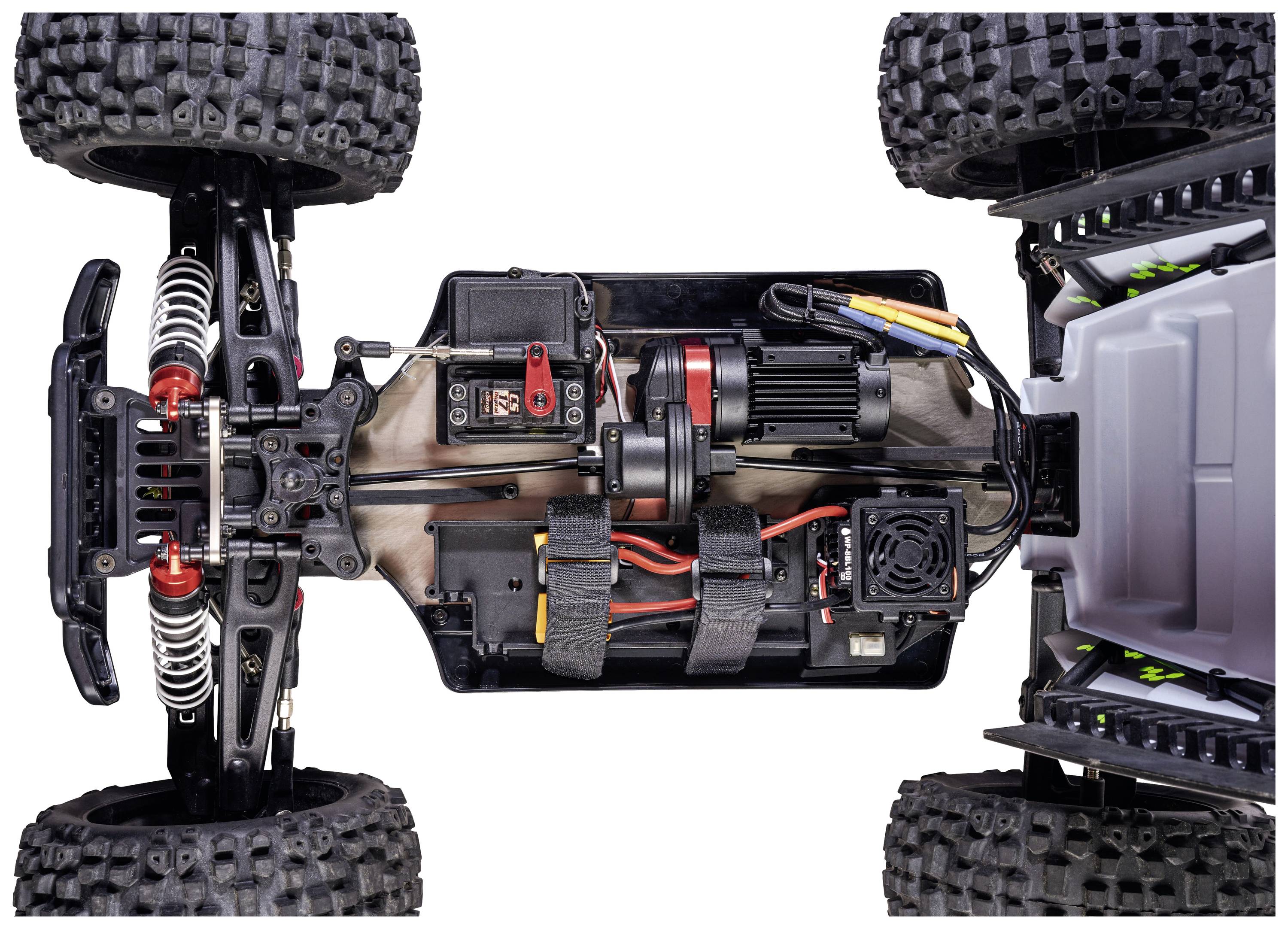Remote-controlled car viewed from above, showing the internal electronics and wiring, with large, robust tyres and visible suspension.