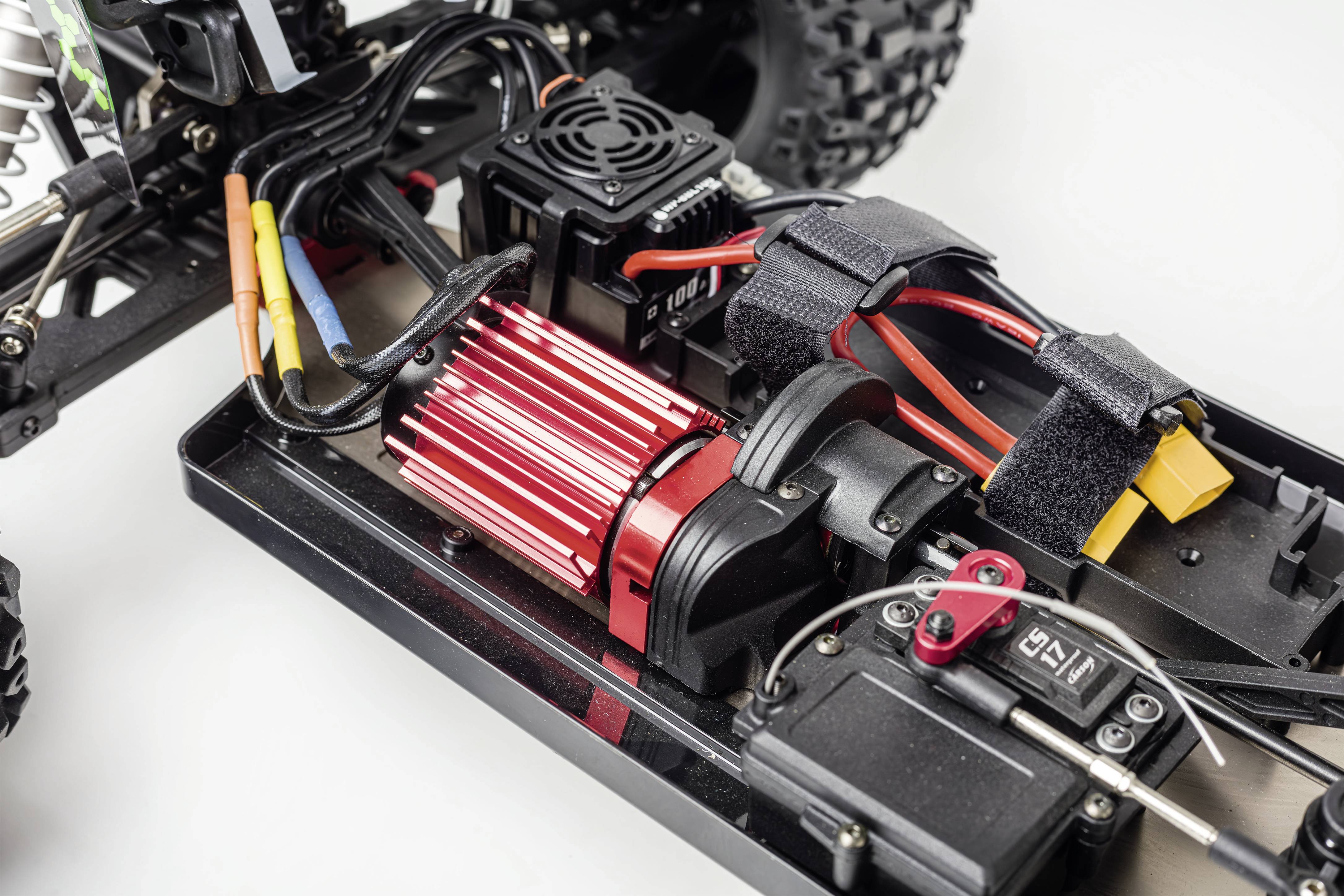 Close-up of a remote-controlled car revealing the motor, wiring and other technical components.