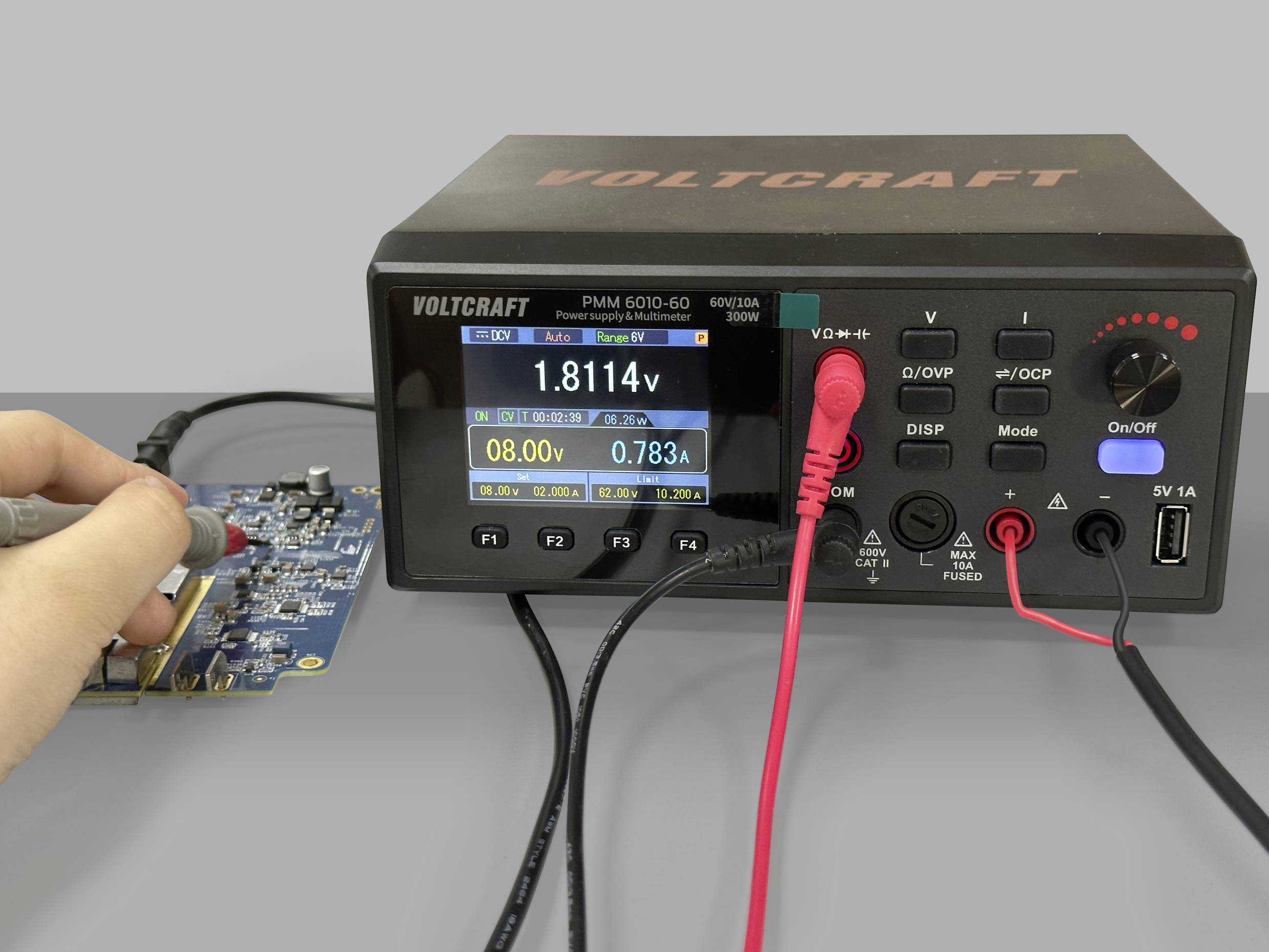 'A person is measuring the voltage on an electronic circuit board using a soldering iron. A measuring device is displaying various readings.'