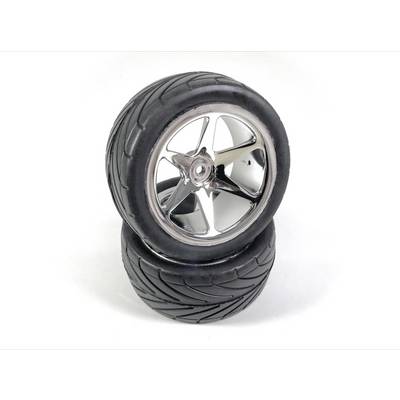 Two black car tyres with gleaming rims are stacked. The tyres have a deep tread pattern.