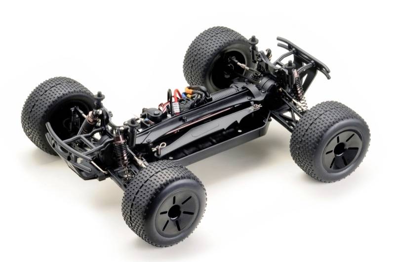 A remote-controlled car chassis with large, chunky tyres and visible suspension on a white background.