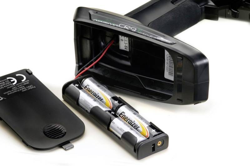 An open barcode scanner with the battery compartment cover removed and batteries inserted.