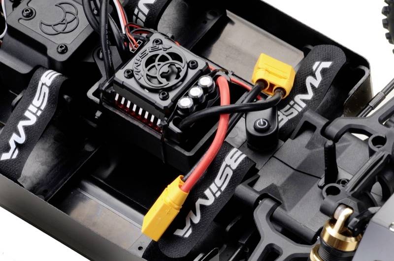 Close-up of a remote-controlled car chassis with visible electronics and wiring.