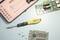 A yellow screwdriver is lying between computer circuit boards and screws on a light blue table. An open case with bits is visible.