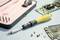 A yellow screwdriver lies with bits and an electronic circuit board on a table. Repair tool and electronics in close-up.
