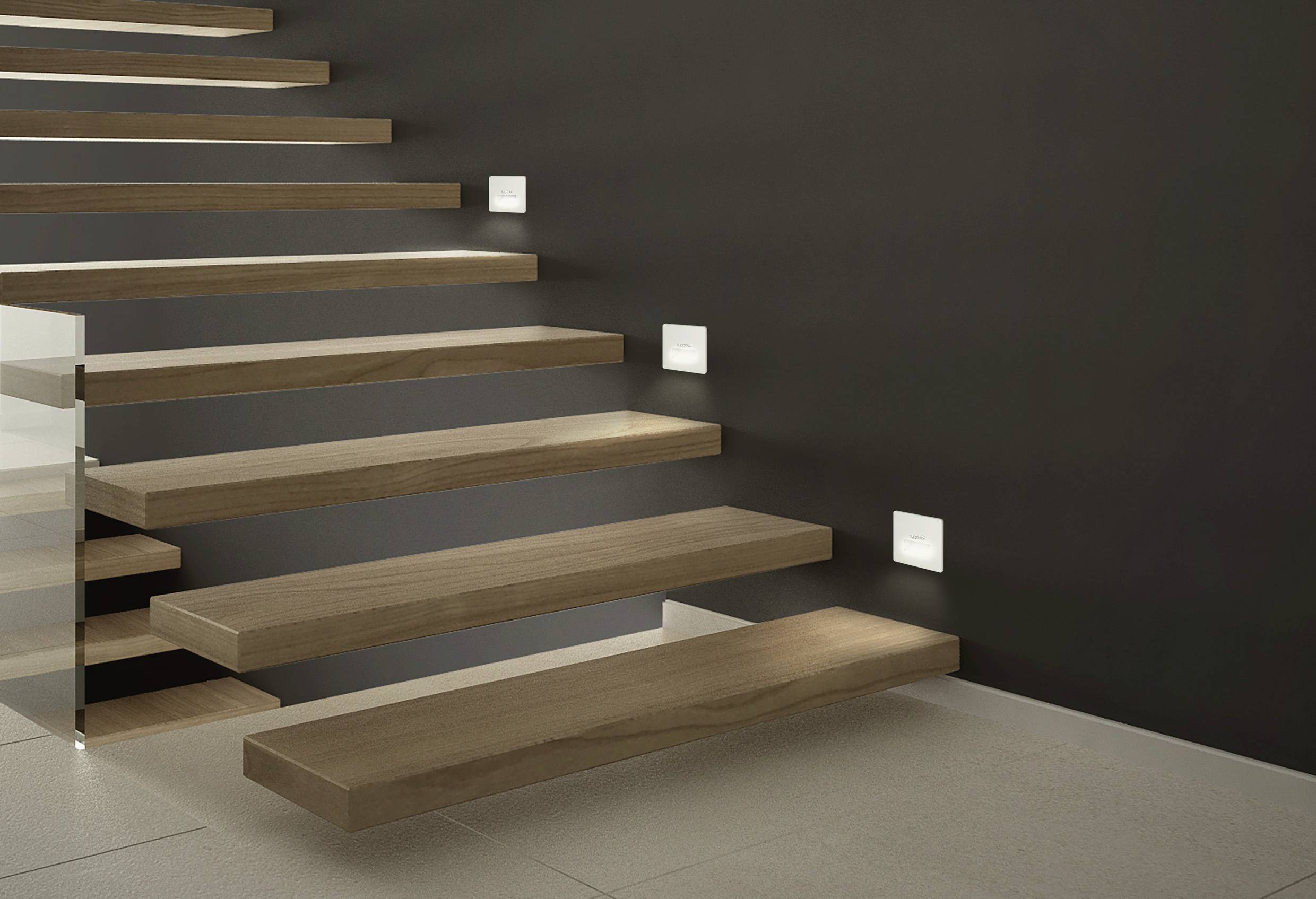 Wooden staircase with floating steps against a dark wall. Built-in lights illuminate the steps from the side.