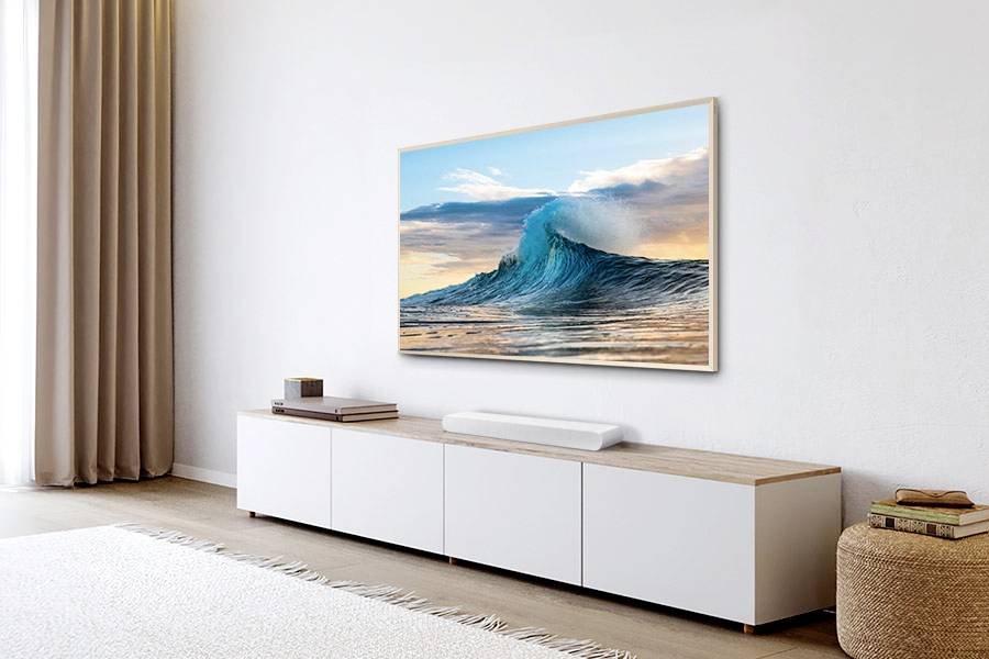 Wave-like artwork on the wall above a low, white sideboard in a modern-furnished living room with curtains and carpet.
