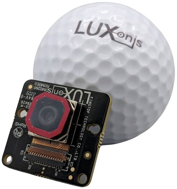 A golf ball-shaped camera next to a real golf ball. The camera has a lens and an electronic disc.