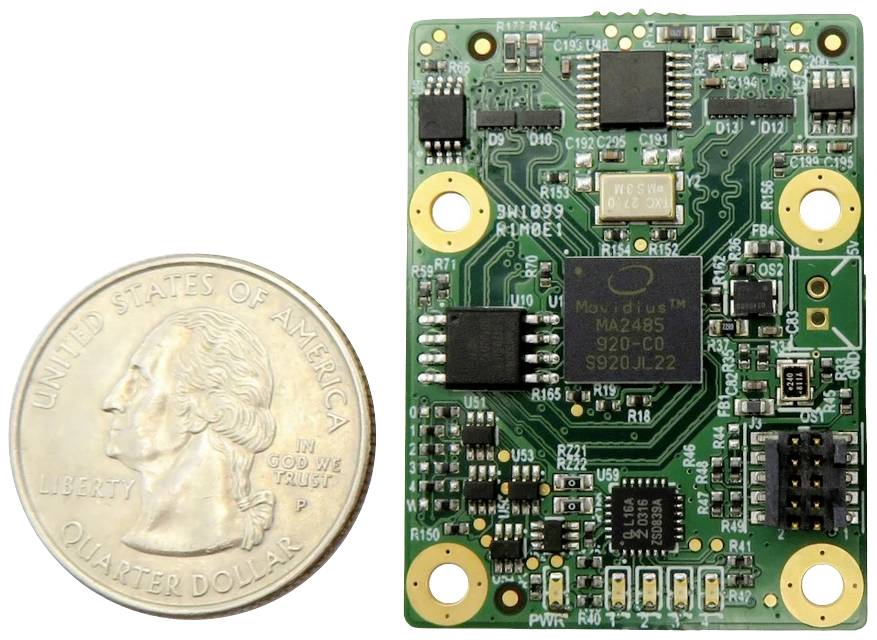 'Size of a microcontroller with an American quarter dollar coin as a reference. The microcontroller displays complex circuitry.'