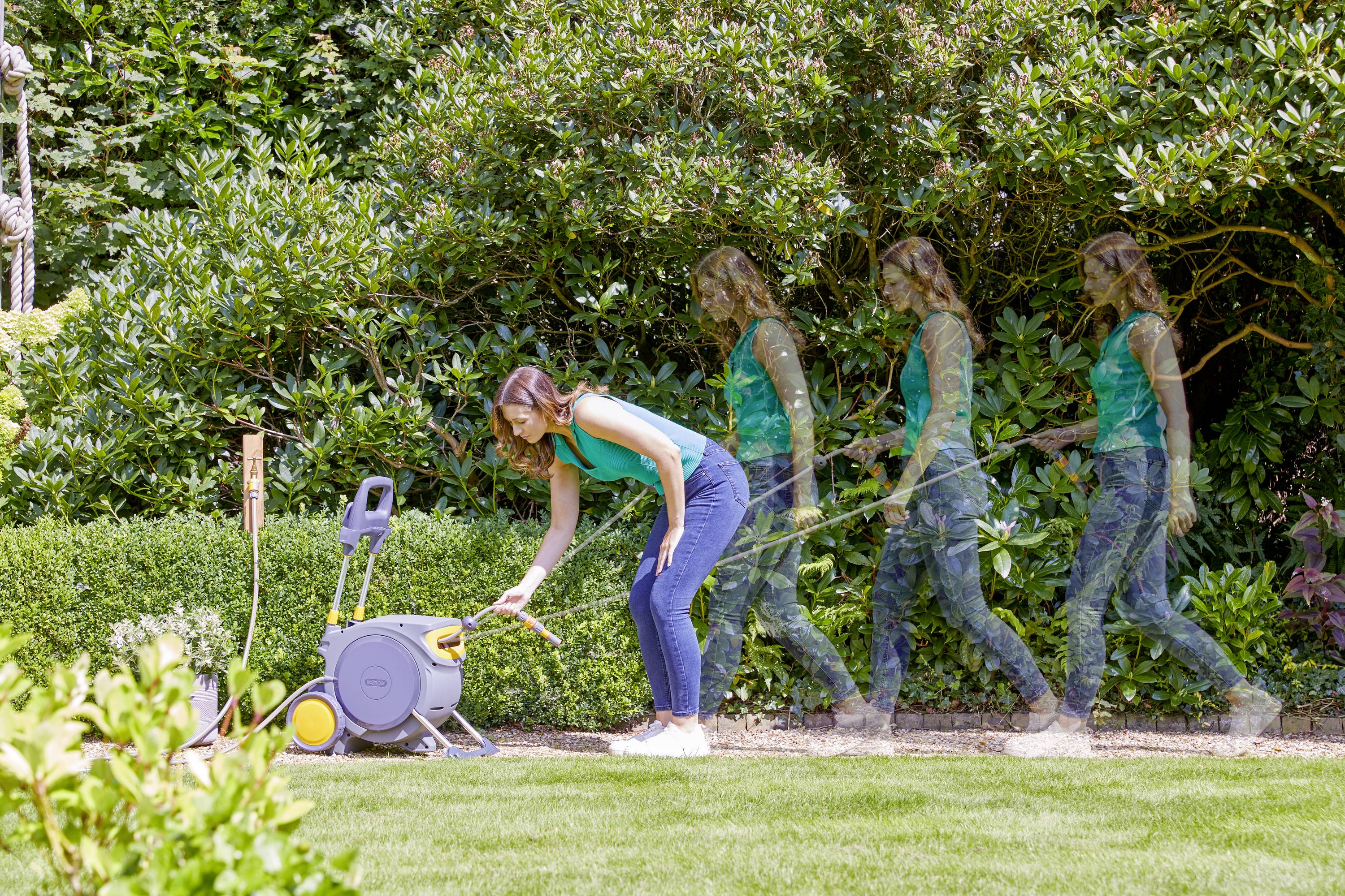 A woman in a garden pulls a garden hose from a hose reel. The movement is shown in several phases.