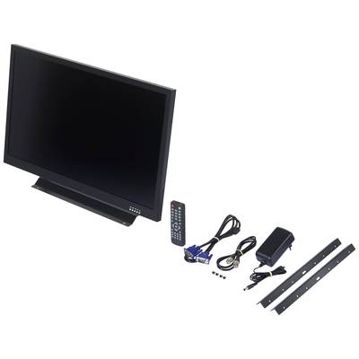 A black monitor with a glossy black screen, with a remote control, cables, an adapter and two mounting brackets lying beside it on a white background.