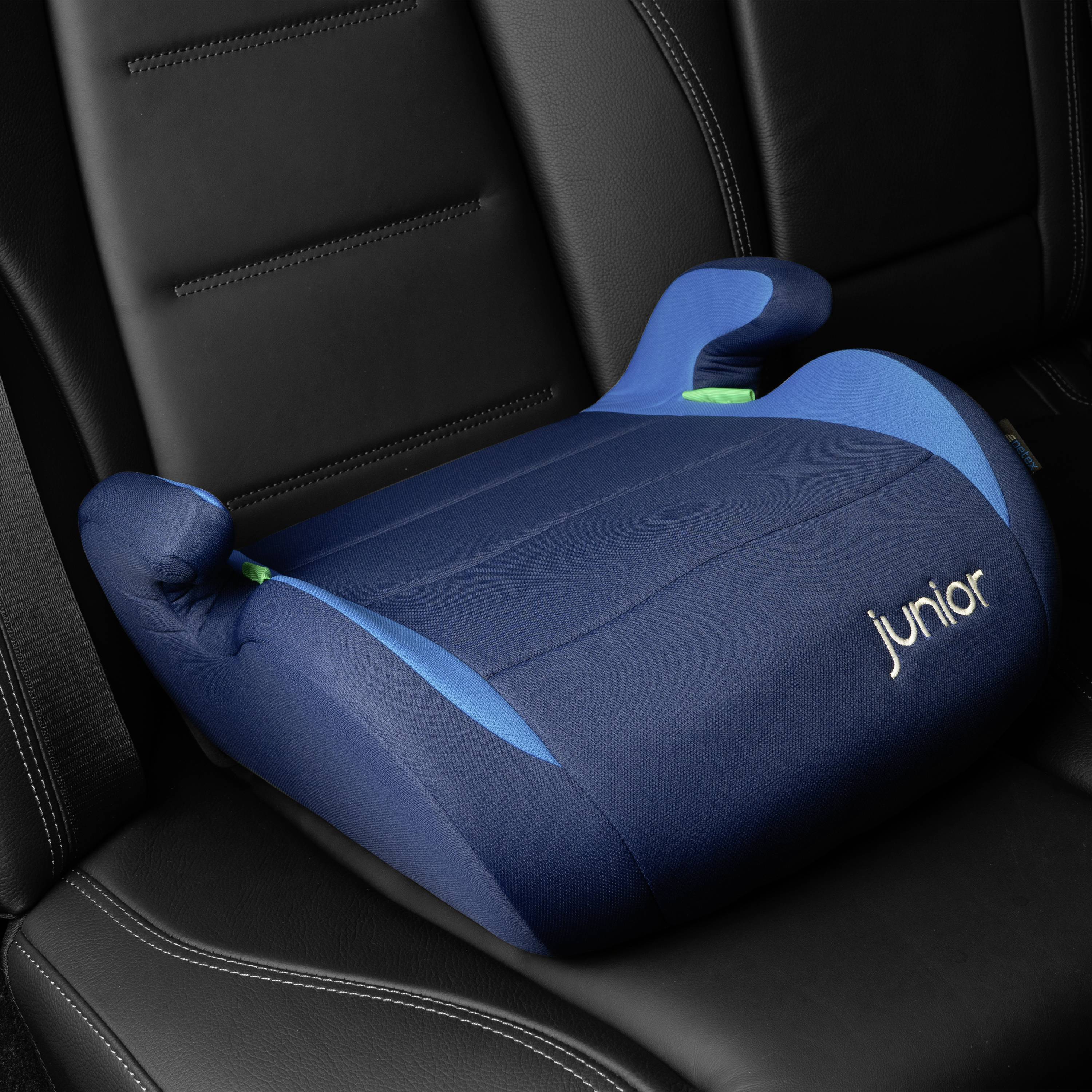 Child car seat with blue upholstery inside a vehicle. Marked with the word 'junior'.