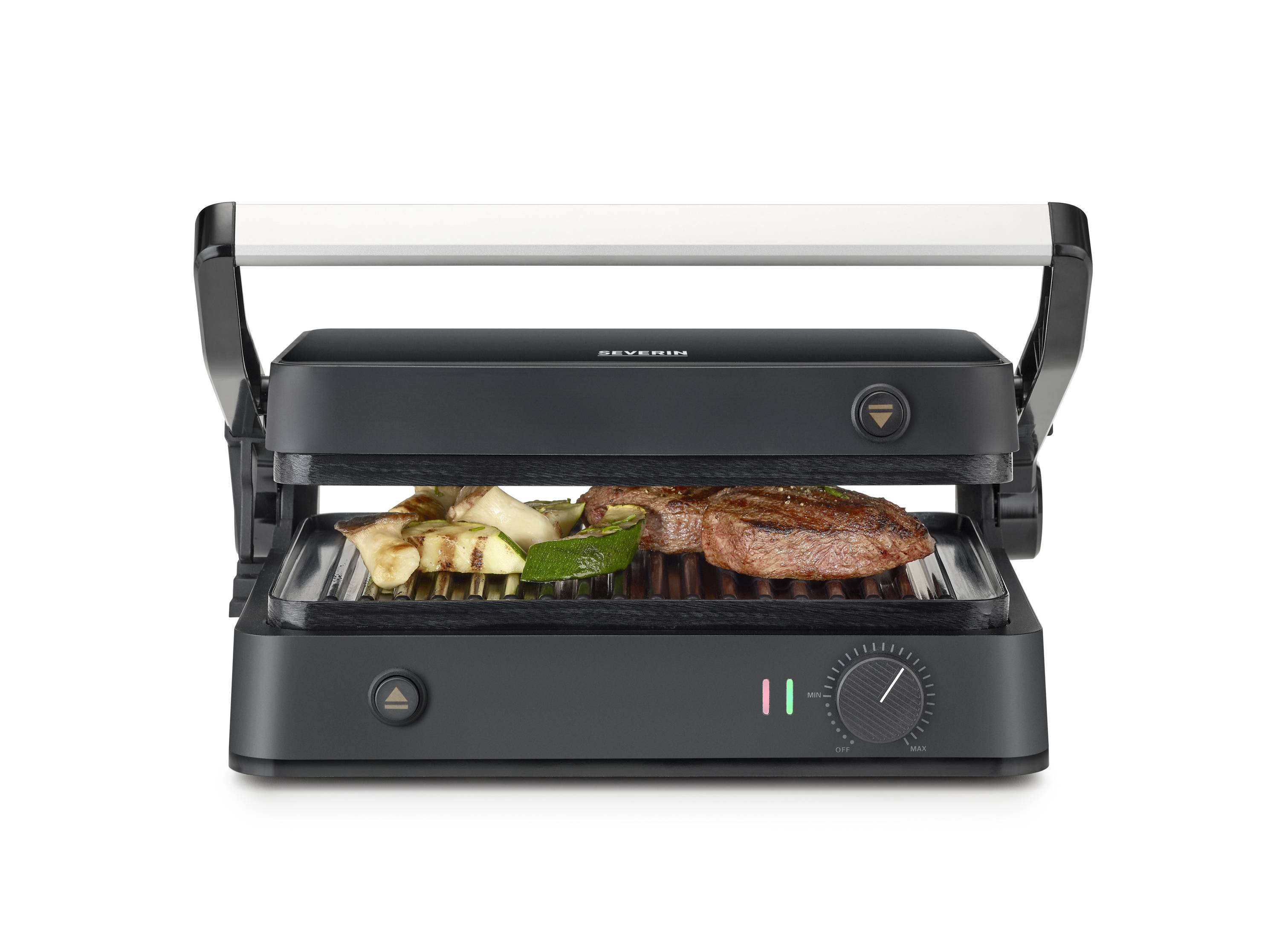 A contact grill with an open lid grills meat and vegetables. The appliance has a dial for temperature adjustment.