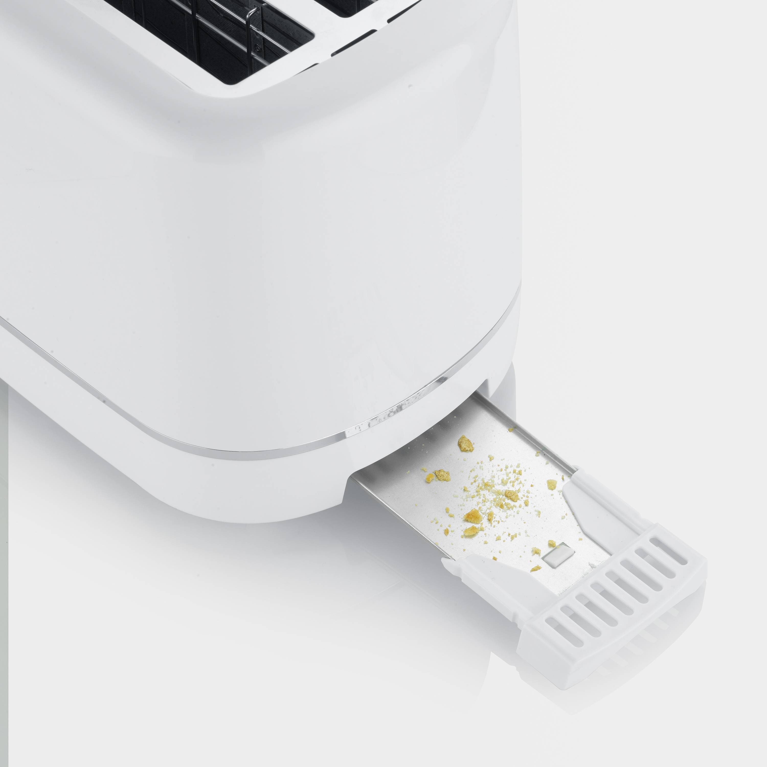 A toaster with a pulled-out crumb tray, with some crumbs visible.