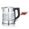 Modern stainless steel and glass kettle with water boiling. Beside it sits a cup of tea with raspberries and mint.