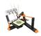 Device with pens draws complex pattern on paper on a table; mechanical arms and accessories visible.