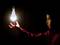 A boy stretches out his hand as if levitating a glowing light bulb that illuminates the darkness.